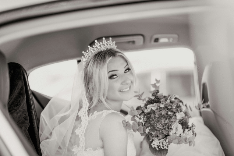 A bride looks happy and stress-free in a car.