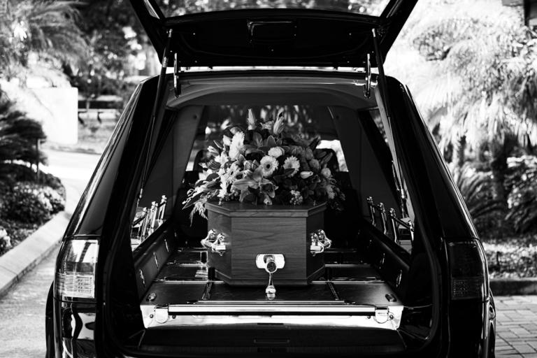 A funeral car with a coffin.